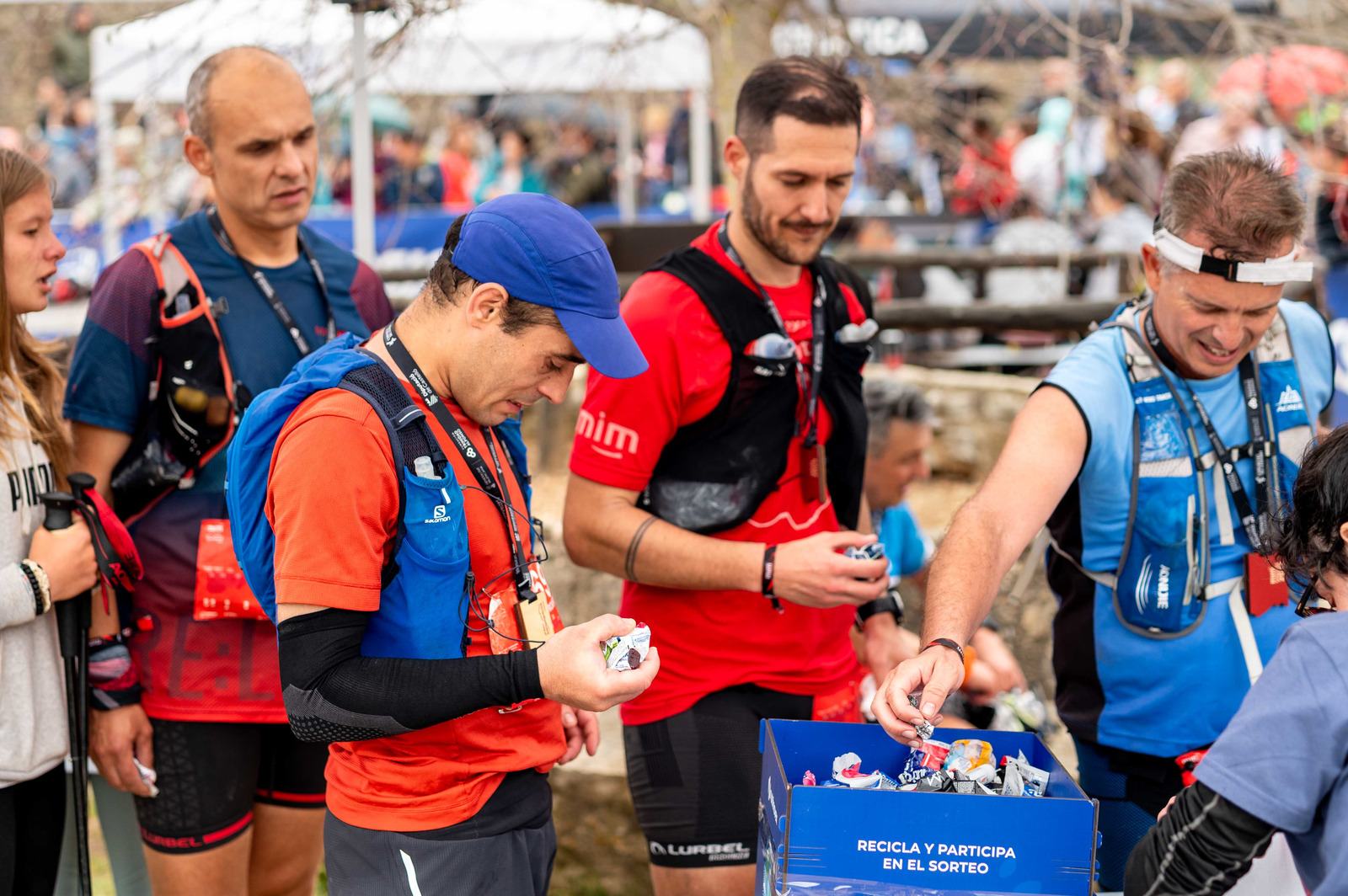 Corredores entregando envoltorios en una caja de recogida