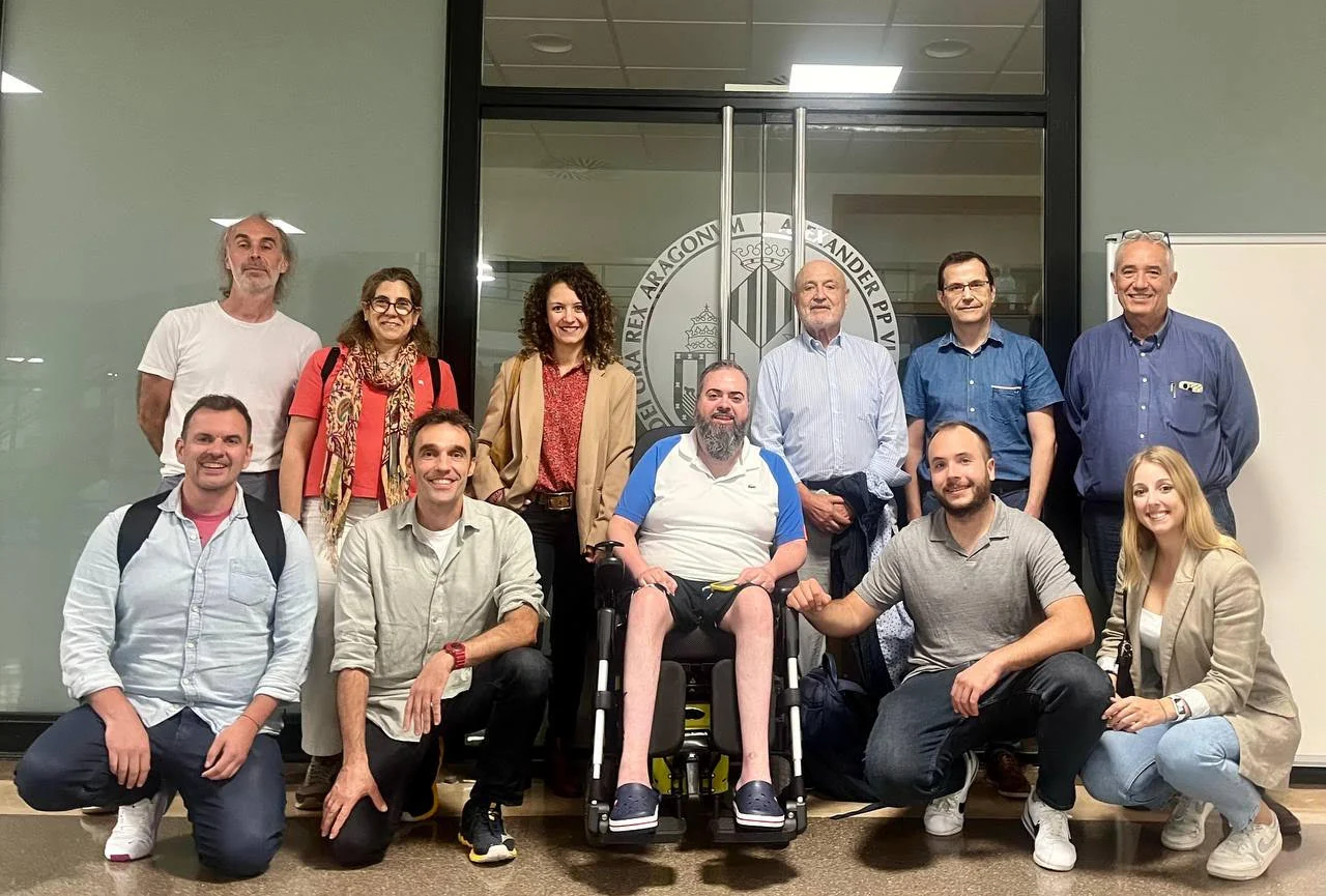Grupo de personas posando a la entrada de un edificio